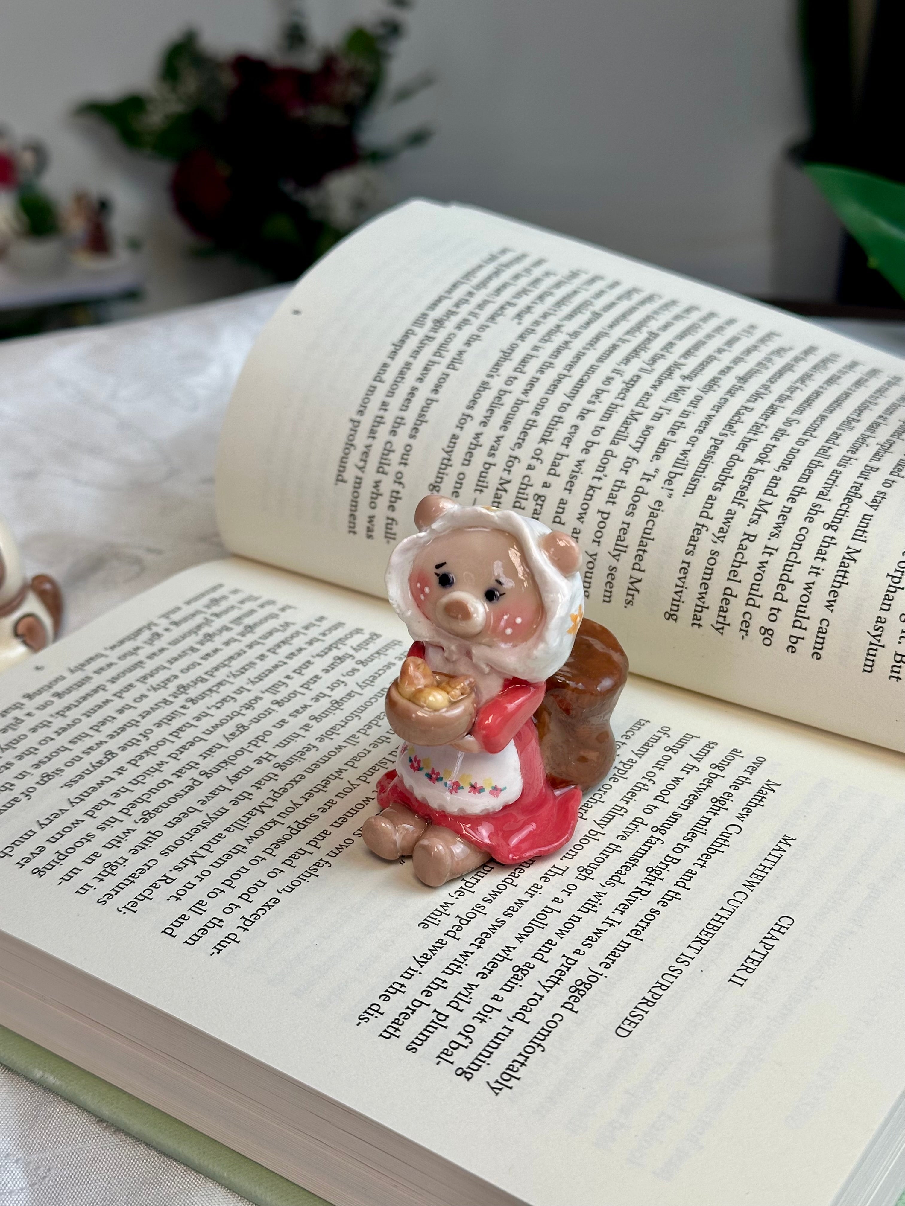 Small figurine of a bear in a dress standing on an open book