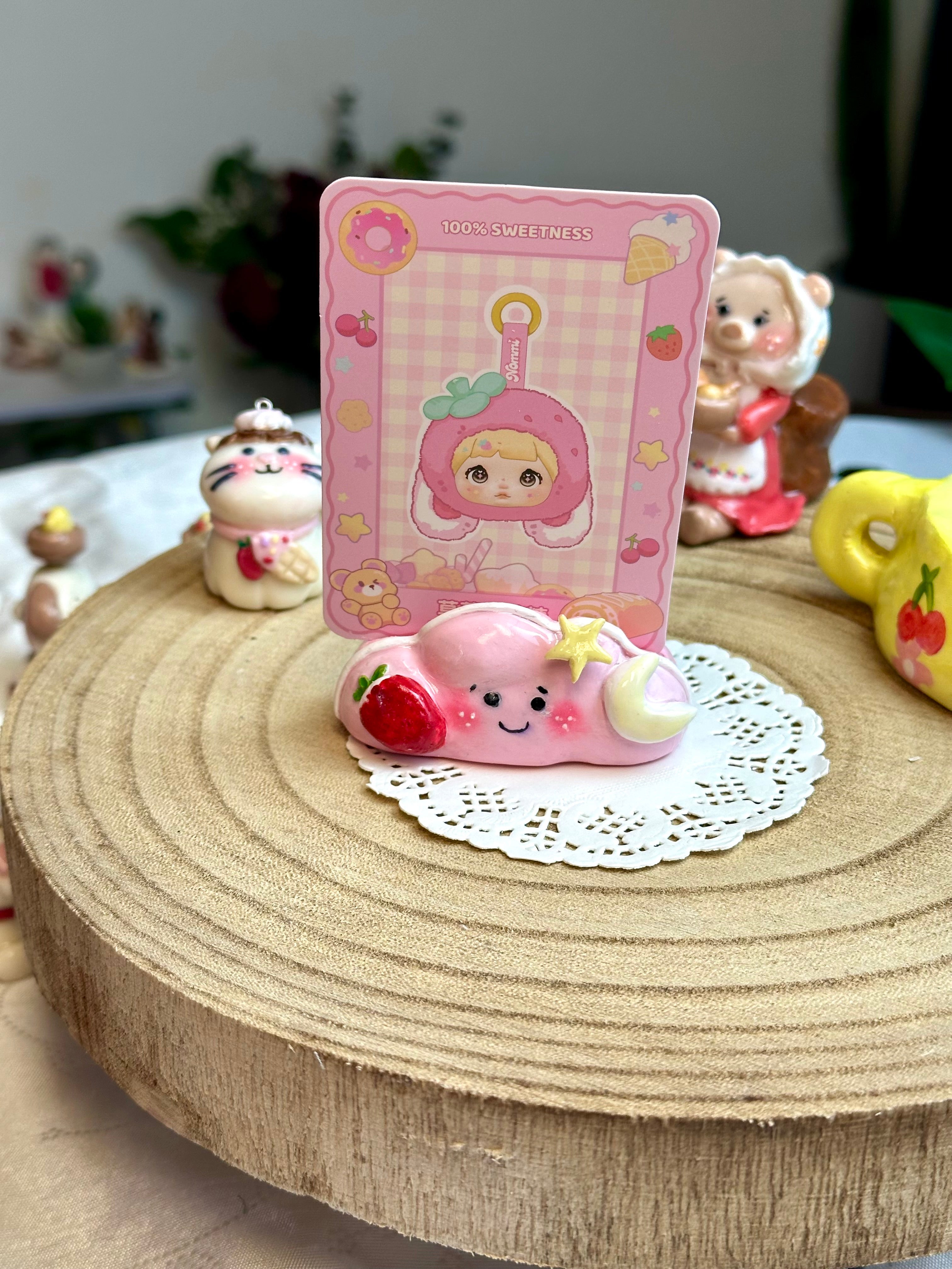 Cute cloud spinner photo holder with a pink card on a wooden surface